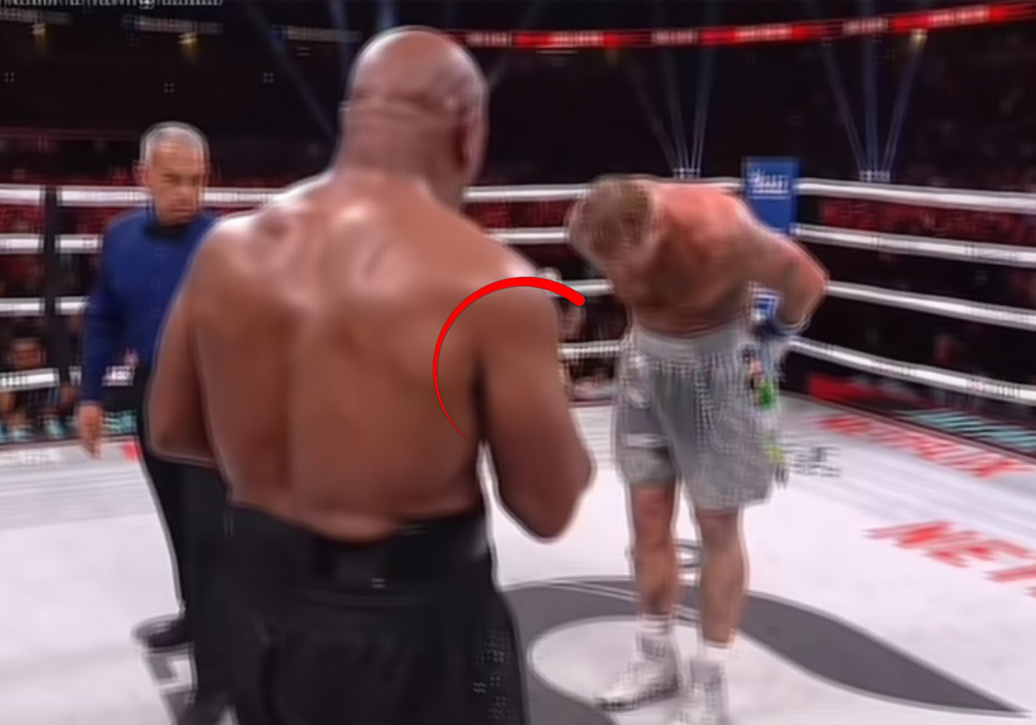 Jake Paul lands a punch on Mike Tyson during their boxing match, with Tyson looking visibly tired and slow in the ring at AT&T Stadium.